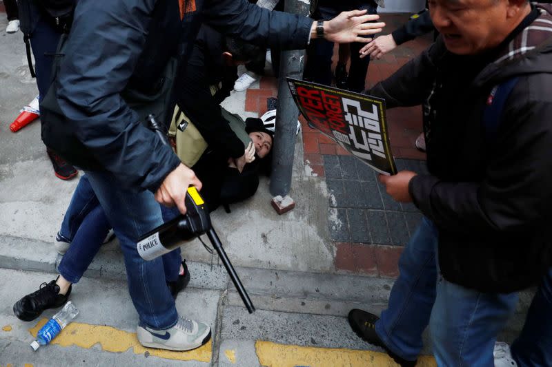A woman is detained by plain-cloth police officers during an anti-government demonstration on New Year's Day, to call for better governance and democratic reforms in Hong Kong