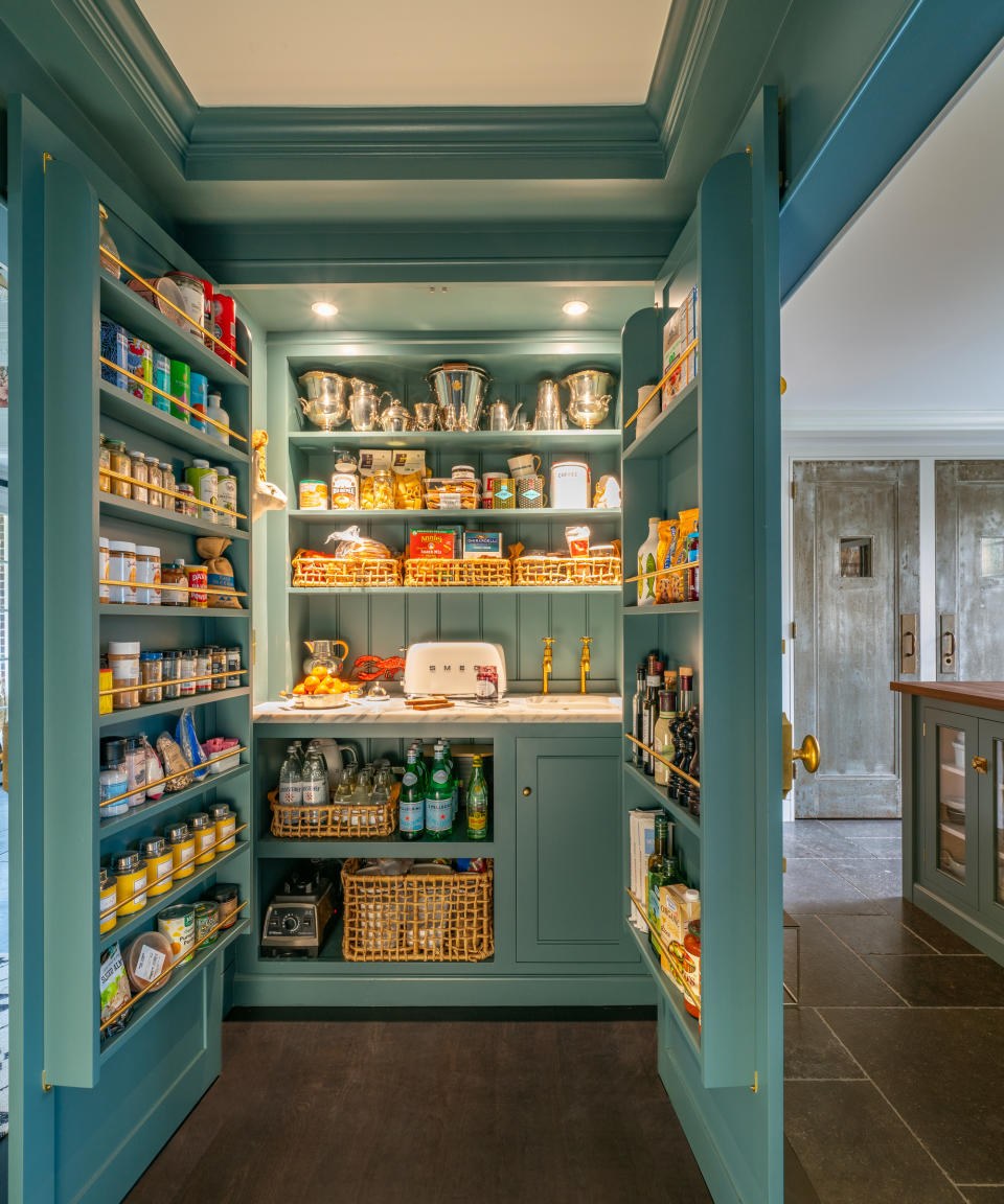 Walk-in pantry with double doors opening onto a breakfast station, with shelving on the inside of the doors