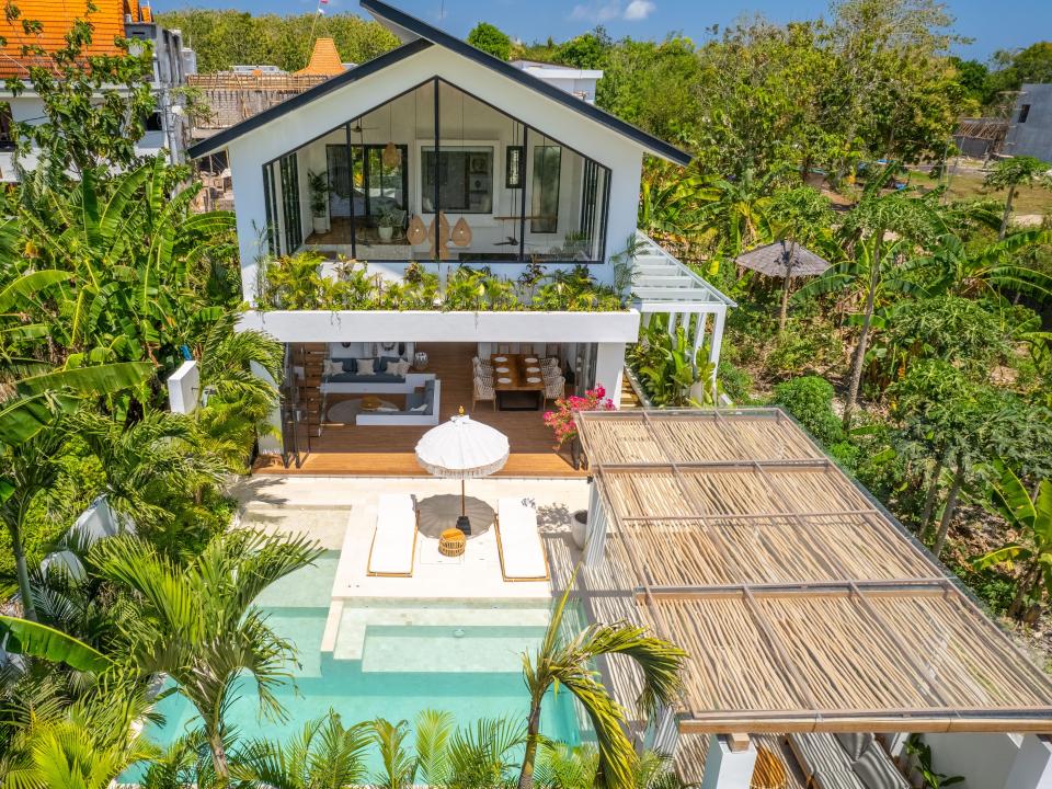 An above view of the front of a two-storey villa with a pool.