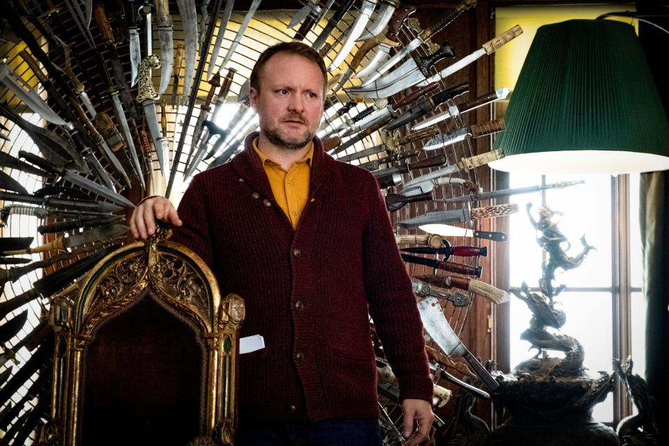 Rian Johnson stands in front of a chair made of knives