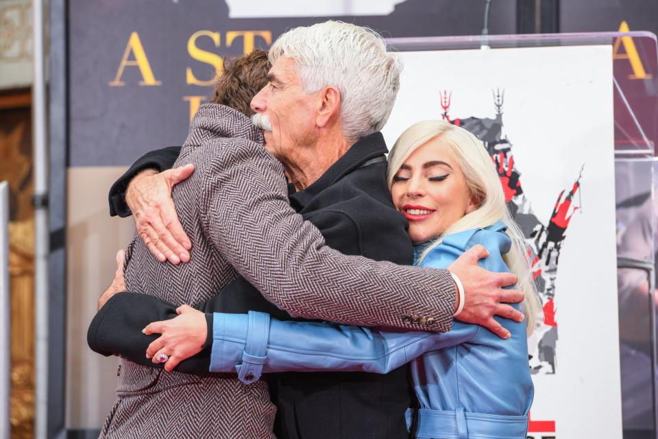 Bradley Cooper, Sam Elliott and Lady Gaga embrace during