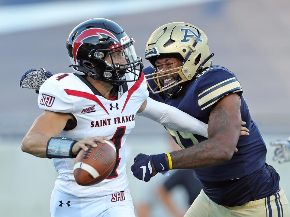 Akron Zips defensive lineman Victor Jones (44) attempts to wrap up St. Francis (Pa) Red Flash quarterback Cole Doyle (4) during the first half of an NCAA football game, Thursday, Sept. 1, 2022, in Akron, Ohio.