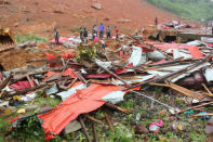 People inspect the damage after a mudslide in the mountain town of Regent, Sierra Leone. REUTERS/Ernest Henry