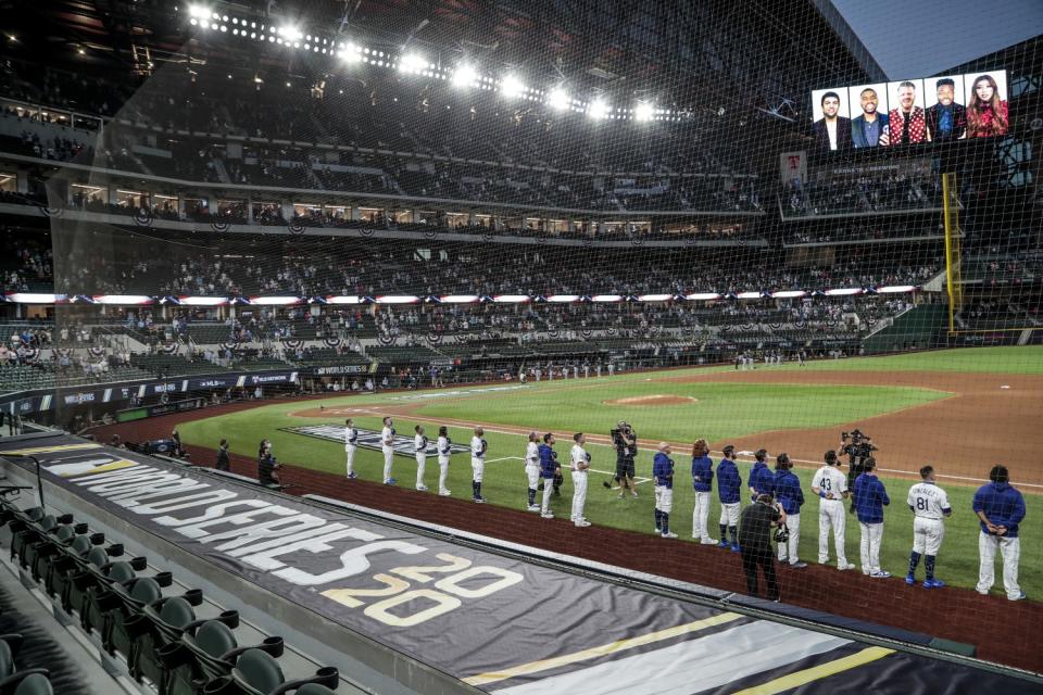 The Dodgers and the Tampa Bay Rays stand during the national anthem.