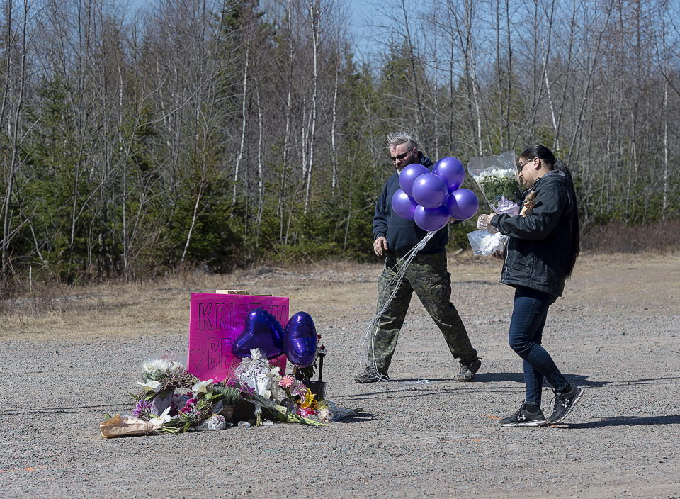 A memorial pays tribute to health-care worker Kristen Beaton along the highway in Debert, Nova Scotia, on Tuesday, April 21, 2020. Canadian police are investigating at 16 crime scenes after a weekend rampage by a gunman disguised as a police officer left at least 18 dead, including Stevenson, and homes in smoldering ruins in rural communities across Nova Scotia. (Andrew Vaughan/The Canadian Press via AP)