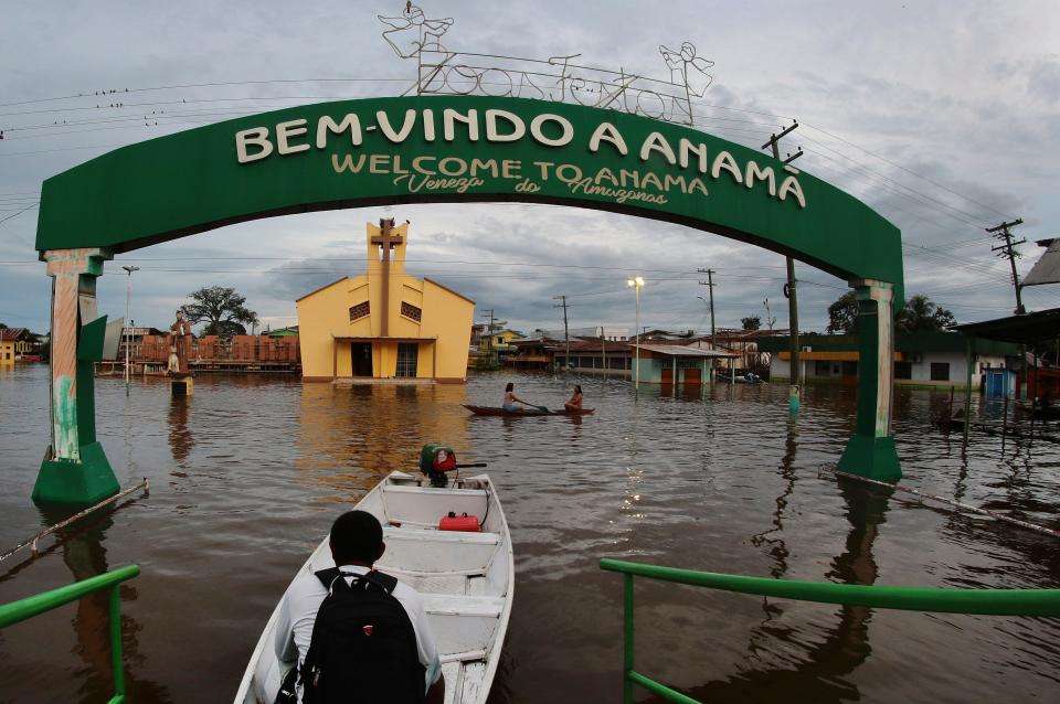 Residents navigate flooded streets in Anama, Amazonas state, Brazil