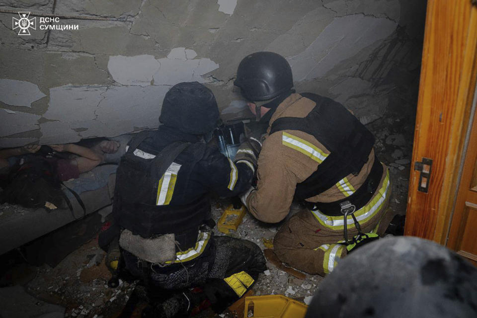 In this photo provided by the Ukrainian Emergency Service on Wednesday, March 13, 2024, emergency services work to save injured people at an apartment building destroyed by Russian attack in Sumy, Ukraine. (Ukrainian Emergency Service via AP)
