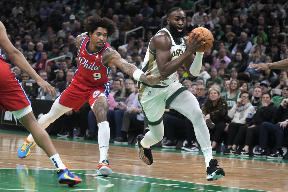 Boston Celtics guard Jaylen Brown, right, drives to the basket past Philadelphia 76ers guard Kelly Oubre Jr. (9) during the first half of an NBA basketball game, Tuesday, Feb. 27, 2024, in Boston. (AP Photo/Charles Krupa)