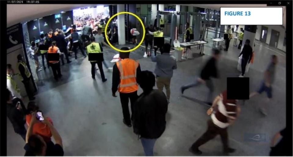 A man holding a young child, and with an older child to his right, tries to extricate a third child from a surge created by the forcing of emergency fire doors (Handout from Baroness Casey Review/PA)