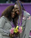 FILE - Serena Williams, left, and Venus Williams of the United States laugh together on the podium after receiving their gold medals in women's doubles at the 2012 Summer Olympics at the All England Lawn Tennis Club in Wimbledon, London, in this Sunday, Aug. 5, 2012, file photo. Serena and Venus Williams, who have a combined nine golds, won't be participating at the Tokyo Games. (AP Photo/Elise Amendola, File)