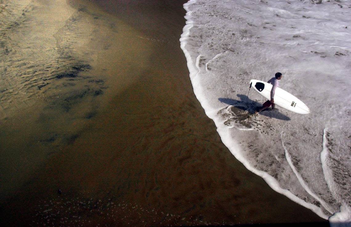 A surfer enters the Atlantic during an afternoon of prime surfing conditions in Rodanthe, N.C. in Sept. 2003. Travis Long/tlong@newsobserver.com