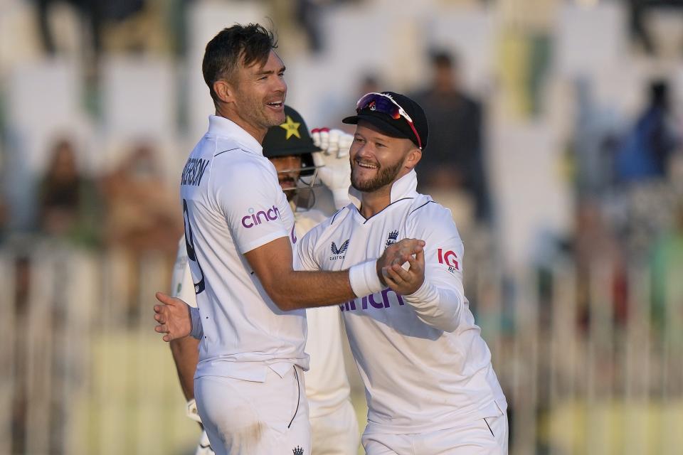 England's James Anderson, left, celebrates with Ben Duckett after taking the wicket of Pakistan's Muhammad Rizwan during the third day of the first test cricket match between Pakistan and England, in Rawalpindi, Pakistan, Saturday, Dec. 3, 2022. (AP Photo/Anjum Naveed)