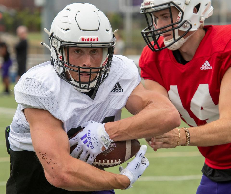 Peter Oliver takes a handoff during Thursday's practice with the Holy Cross football team.