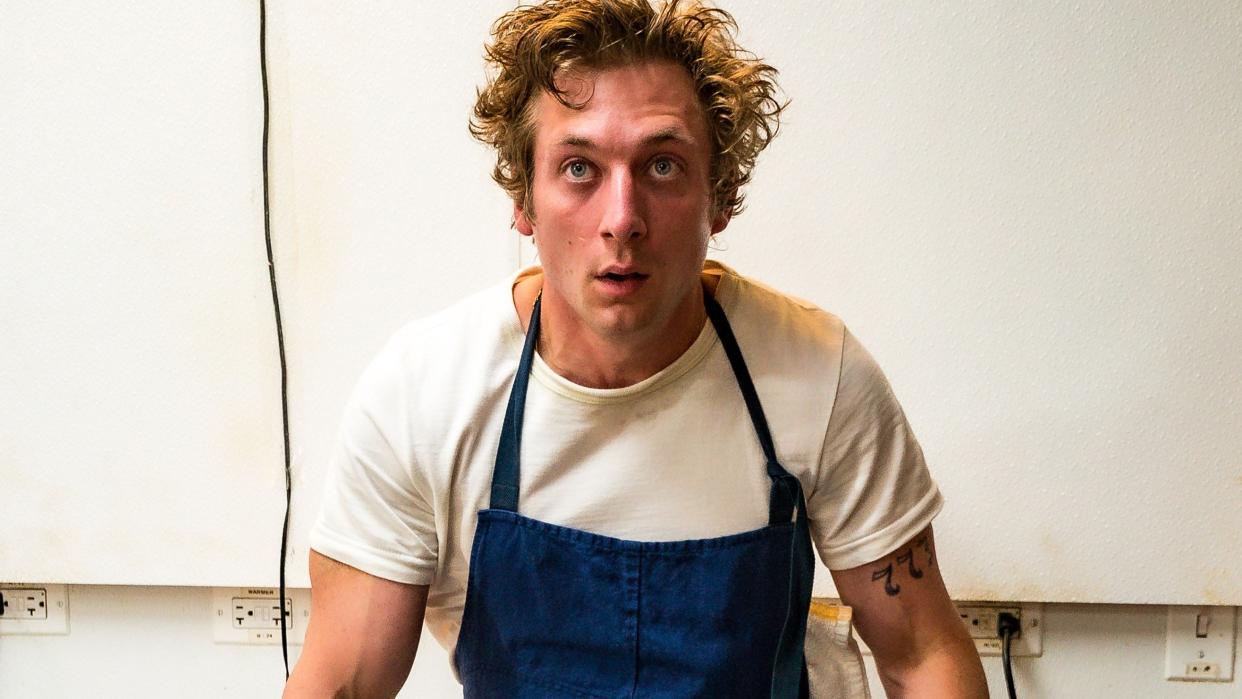  Actor Jeremy Allen White, who plays chef Carmen 'Carmy' Berzatto in The Bear season 2, sits on a metal table in a hot kitchen. 