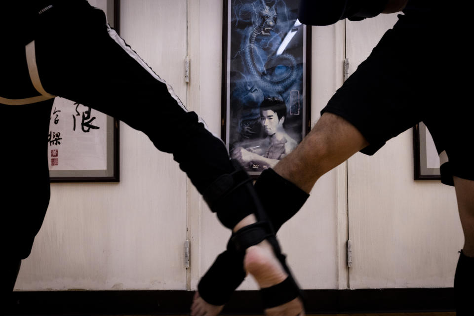 Practitioners train in front of a photo of Bruce Lee during a Jeet Kune Do class in Hong Kong, Wednesday, July 19, 2023. (AP Photo/Louise Delmotte)
