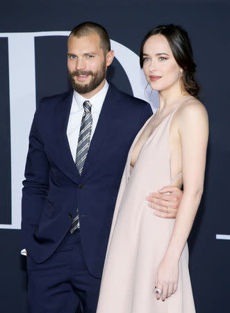 FILE PHOTO - Cast members Jamie Dornan (L) and Dakota Johnson pose at the premiere of the film "Fifty Shades Darker" in Los Angeles, California, U.S. on February 2, 2017. REUTERS/Danny Moloshok/File Photo