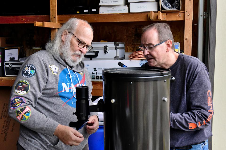 Dan Everly, left, and Bryan Summer of the Crawford Park Astronomy Club look over some of their equipment as they stand inside at Lowe-Volk Park as it rained during last year's annular eclipse.