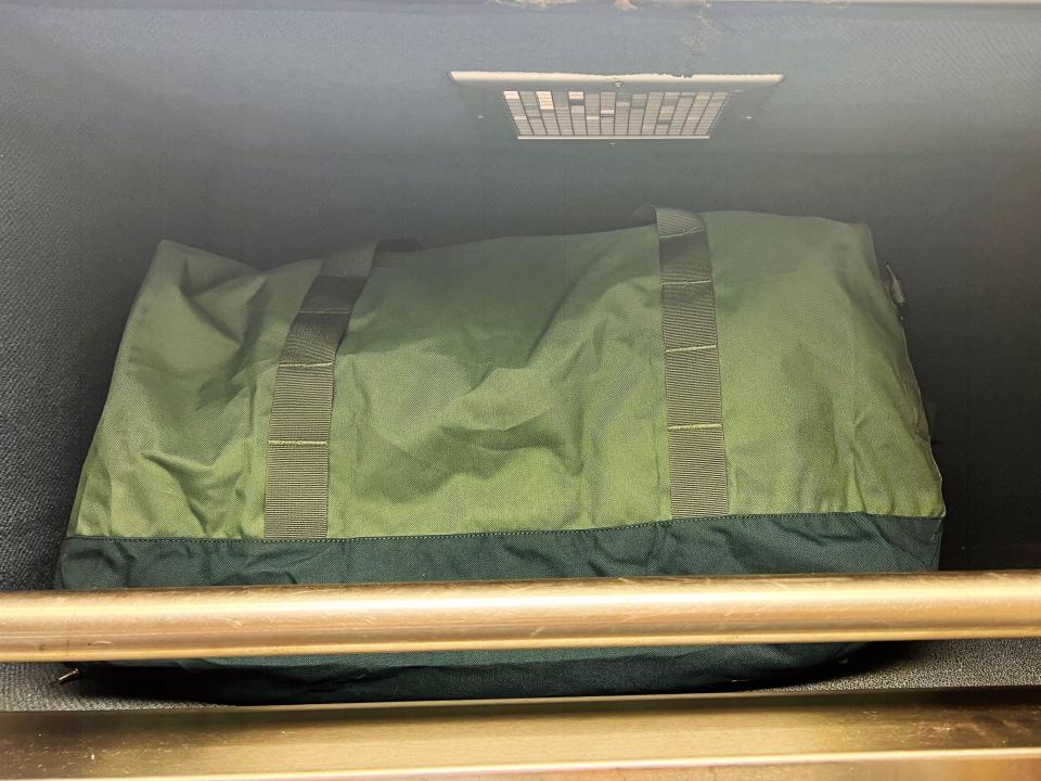 A green bag stored inside the luggage section in the author's Amtrak roomette.