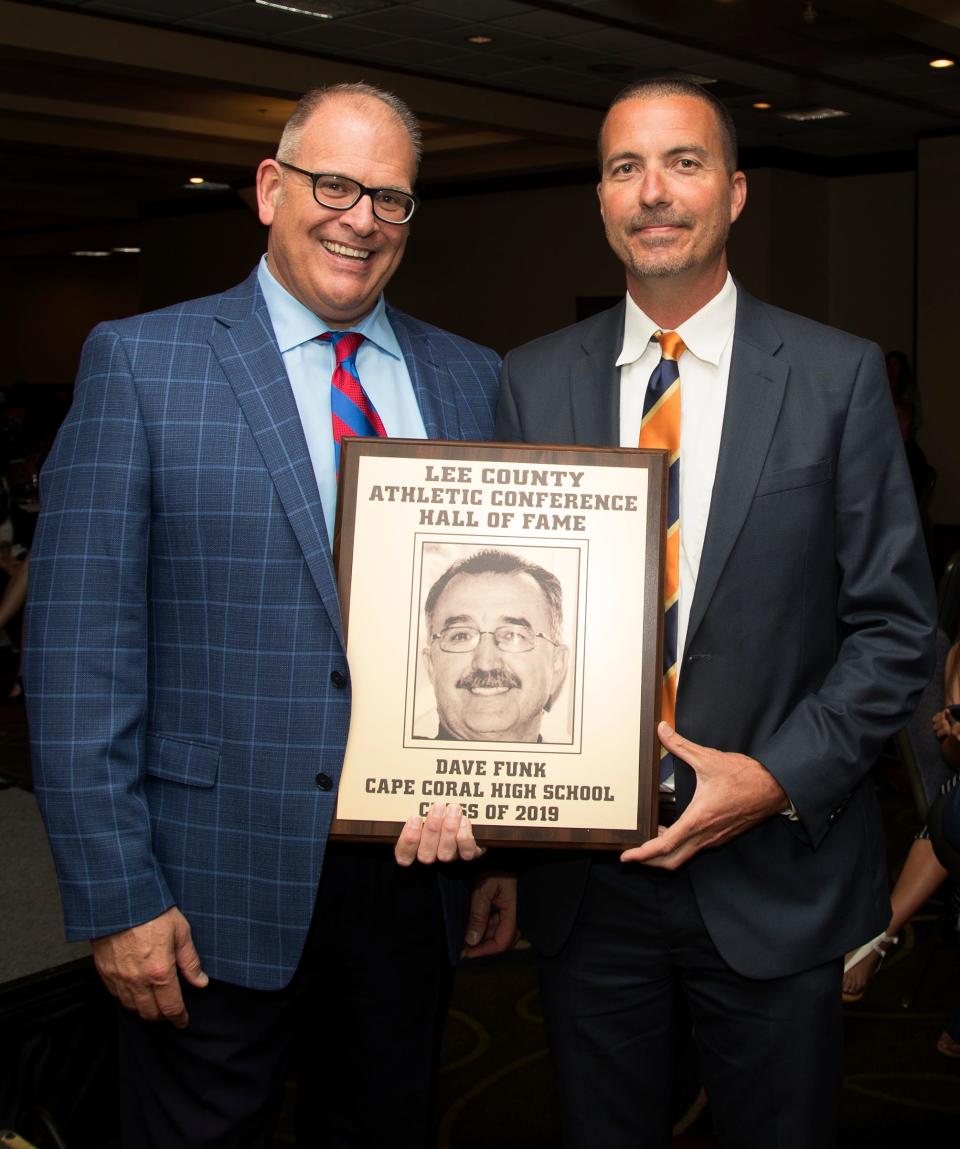 David LaRosa, left, and Tom Kenna, right, accept former Cape Coral High School basketball coach David Funk's  Lee County Athletic Conference Hall of Fame honor on Thursday in Fort Myers.