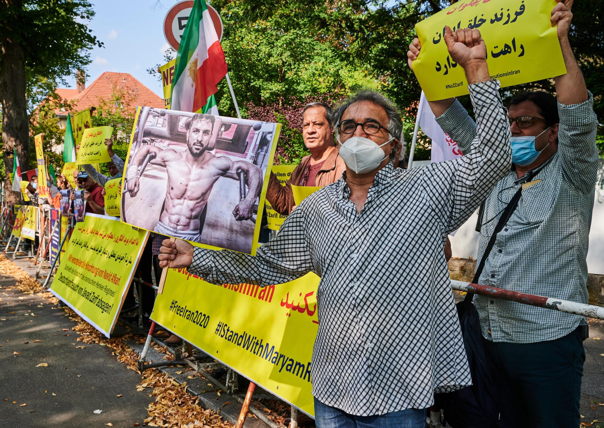 Demonstrators hold pictures of the executed wrestler Navid Afkari in front of the Iranian embassy.