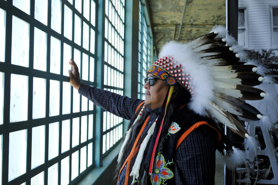 Jason Morsette, of New Town, North Dakota, looks out toward the bay and the Golden Gate Bridge through barred windows during ceremonies for the 50th anniversary of the Native American occupation of Alcatraz Island Wednesday, Nov. 20, 2019, in San Francisco. About 150 people gathered at Alcatraz to mark the 50th anniversary of a takeover of the island by Native American activists. Original occupiers, friends, family and others assembled Wednesday morning for a program that included prayer, songs and speakers. They then headed to the dock to begin restoring messages painted by occupiers on a former barracks building. (AP Photo/Eric Risberg)