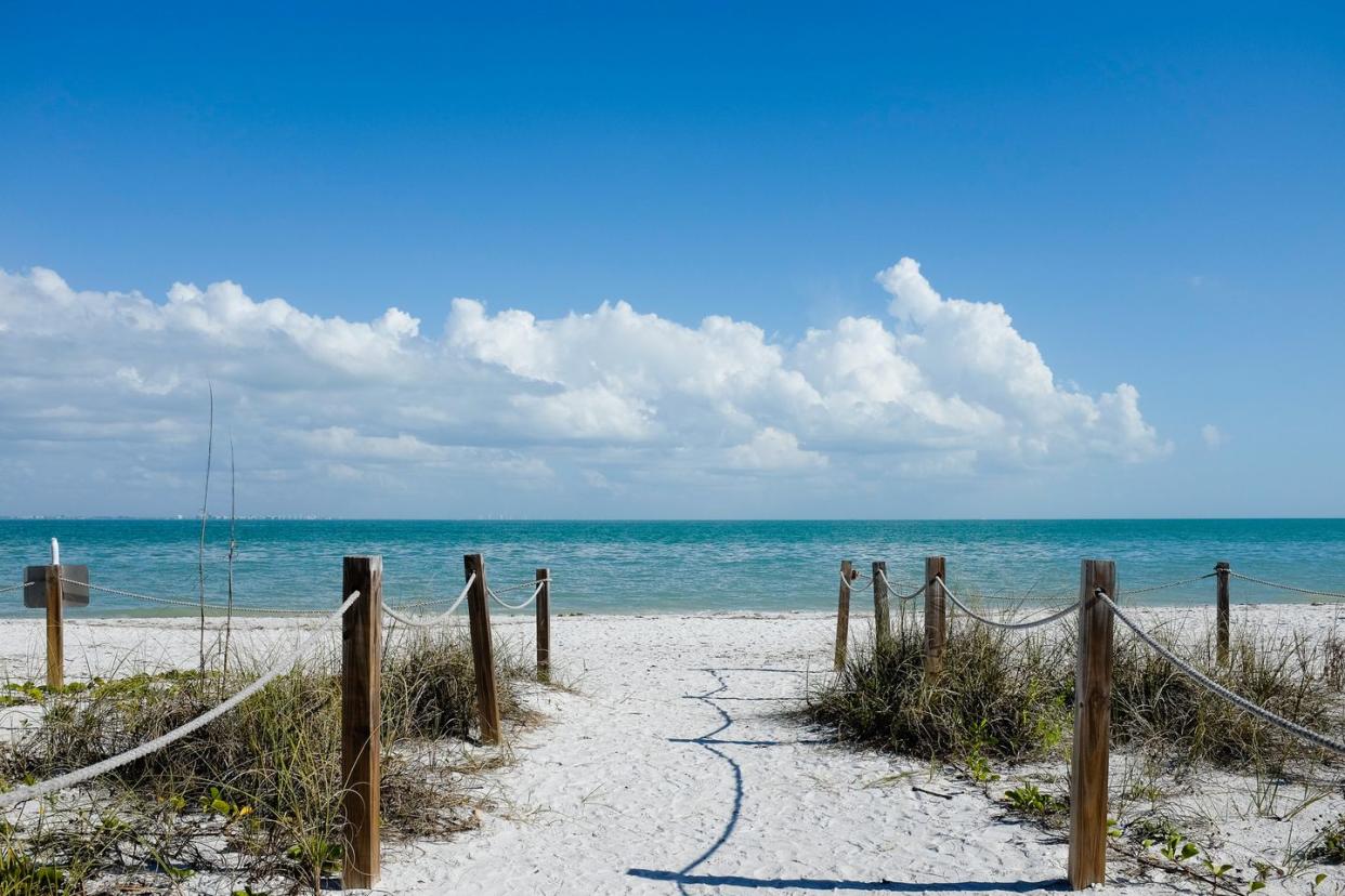 scenic view of sea against sky and sandy path leading to ocean