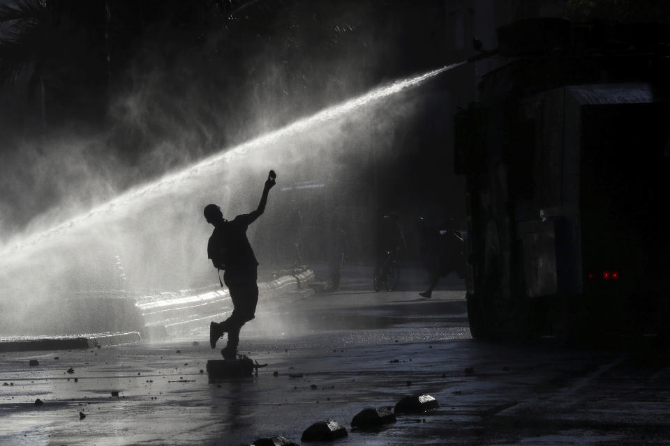 ARCHIVO: Un manifestante antigubernamental arroja una piedra contra un cañón de agua de la policía de Chile durante una protesta en Santiago, Chile, el lunes 9 de diciembre de 2019. (AP Foto / Fernando Llano)