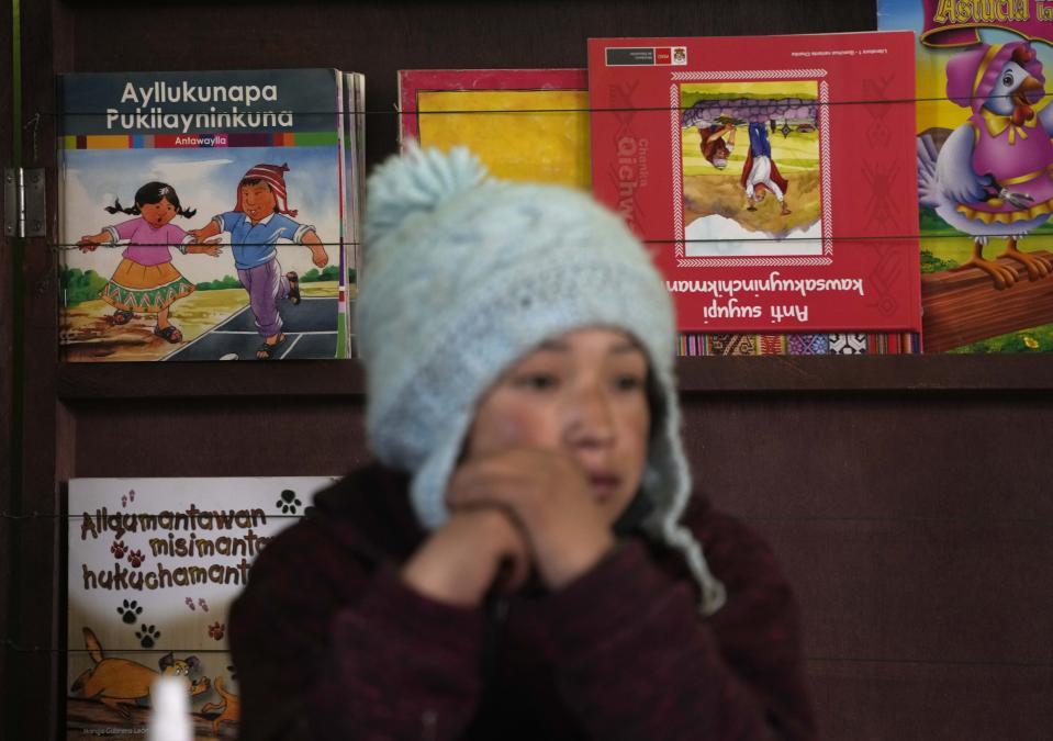 FILE - Books written in the Quechua Indigenous language sit behind a student during a class on medicinal plants, at a public primary school in Licapa, Peru, Wednesday, Sept. 1, 2021. About 10 million people speak Quechua, but trying to automatically translate emails and text messages into the most widely spoken Indigenous language family in the Americas was nearly impossible before Google introduced it into its digital translation service Wednesday, May 11, 2022. The internet giant says new artificial intelligence technology is enabling it to vastly expand Google Translate’s repertoire of the world’s languages, adding 24 more this week including Quechua and other Indigenous South American languages such as Guarani and Aymara. (AP Photo/Martin Mejia)