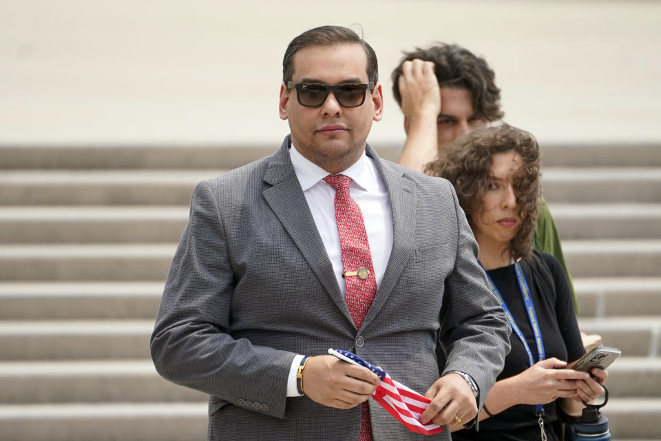 FILE - U.S. Rep. George Santos, R-N.Y., holds a miniature American flag that was presented to him as he departs federal court, June 30, 2023, in Central Islip, N.Y. Prosecutors say the ex-campaign treasurer for Santos is scheduled to enter a guilty plea to an unspecified felony in connection with the federal investigation of financial irregularities surrounding the indicted New York Republican. Nancy Marks is a veteran Long Island political operative. Marks was a campaign treasurer and close aide to Santos during his two congressional bids. (AP Photo/John Minchillo, File)