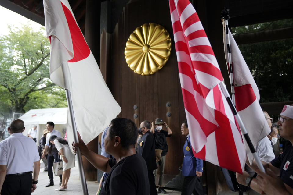 Members of right wing groups with Japanese national flags, enter the Yasukuni Shrine, which honors Japan's war dead, Tuesday, Aug. 15, 2023, in Tokyo. Japan holds annual memorial service for the war dead as the country marks the 78th anniversary of its defeat in the World War II. (AP Photo/Eugene Hoshiko)