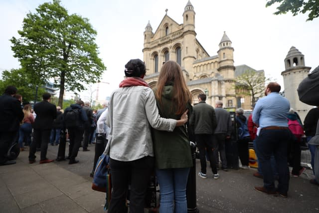 Mourners listen to the service