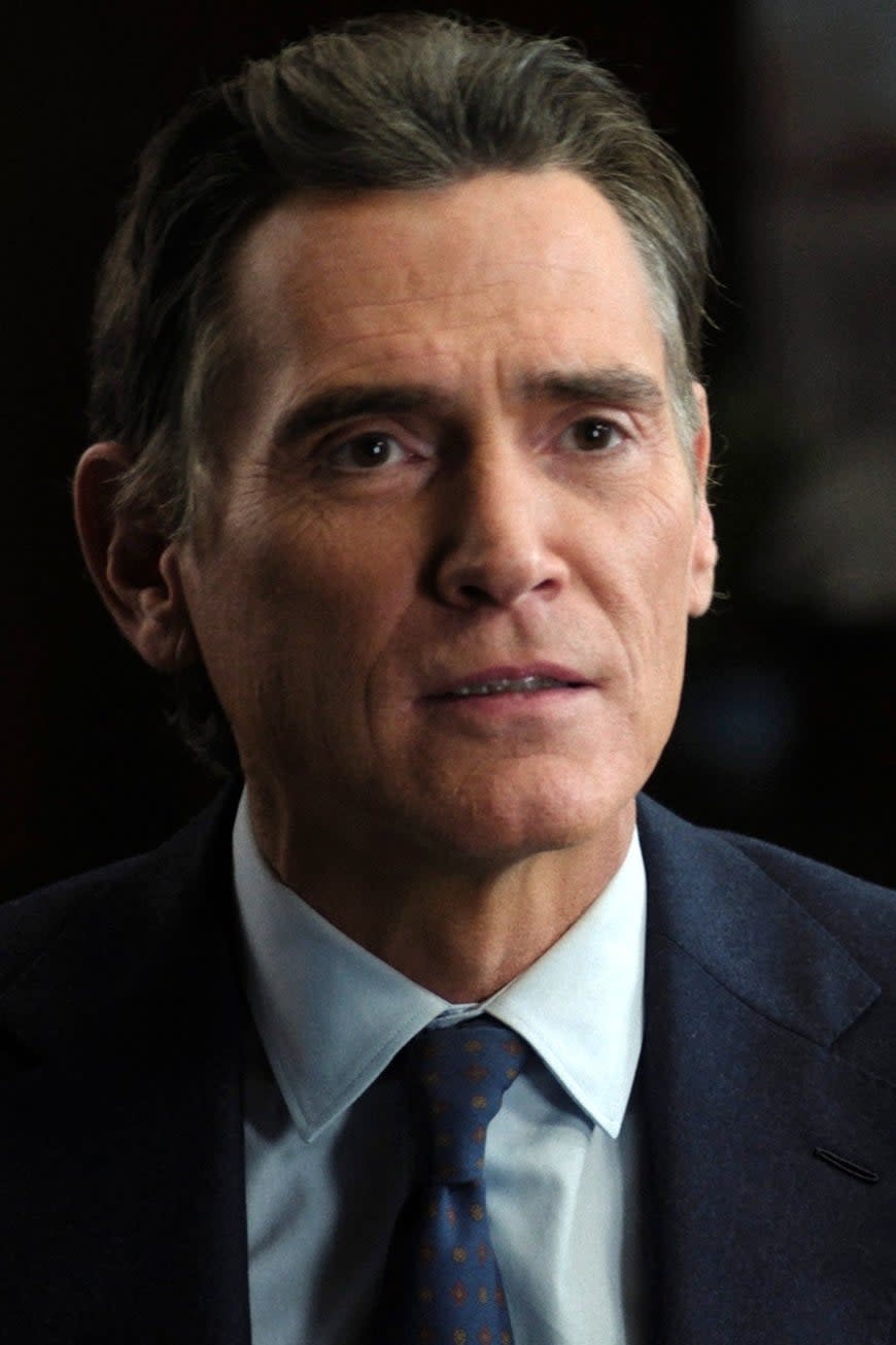 Billy Crudup, wearing a suit and tie, in a serious conversation with an unseen person in a scene from a TV show or movie