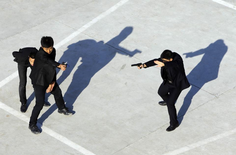 Trainees holding replica pistols take part in a training session of employer protection on the outskirts of Beijing