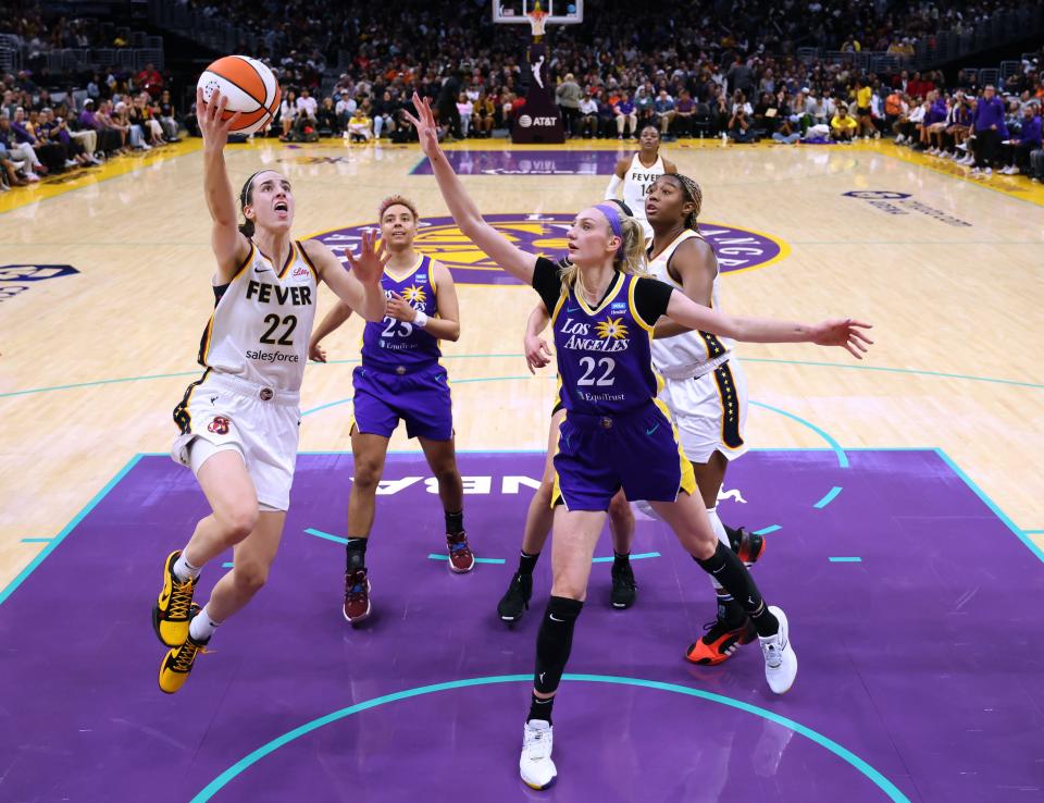 Caitlin Clark #22 of the Indiana Fever scores on a layup past Cameron Brink #22 of the Los Angeles Sparks during a 78-73 Fever win at Crypto.com Arena on May 24, 2024, in Los Angeles, California.