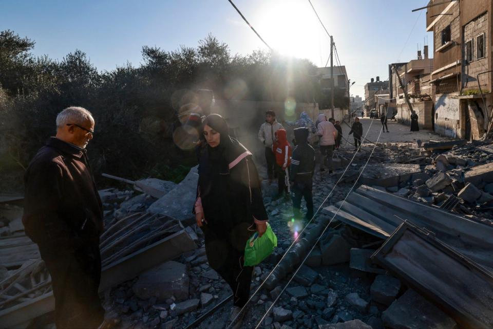 Palestinians walk through the rubble of a building destroyed by Israeli bombardment on Rafah (AFP via Getty Images)