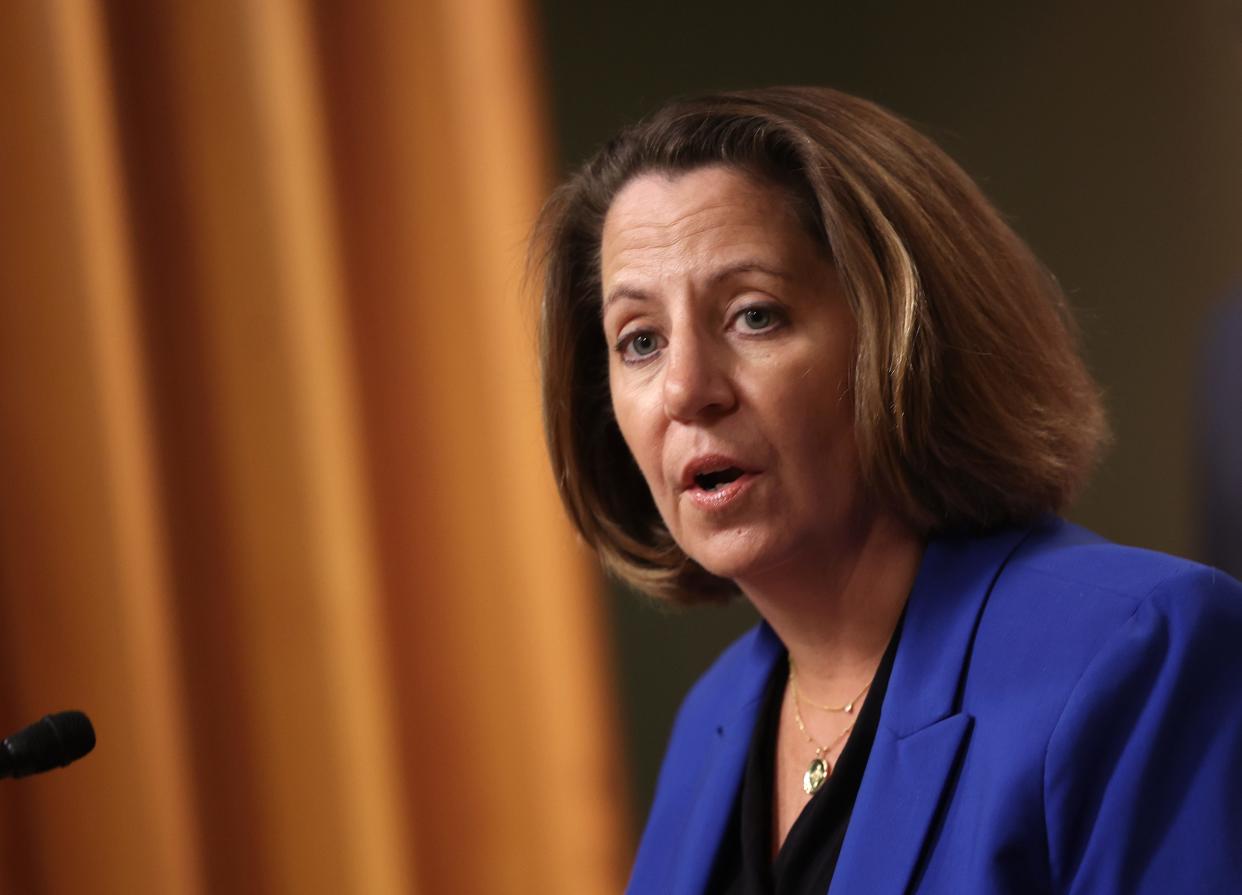 Deputy Attorney General Lisa Monaco speaks into a microphone during a Department of Justice press conference.