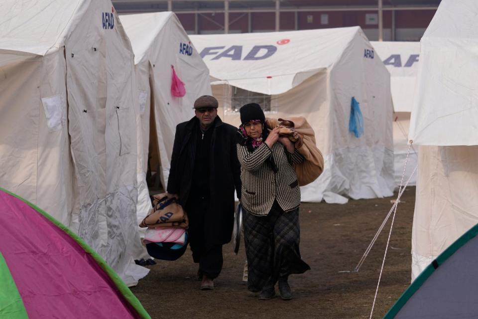 People with their belongings arrive at the tents, in Kharamanmaras, southeastern Turkey (AP)