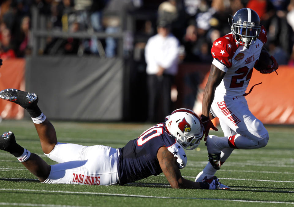 South running back Jerick McKinnon, of Georgia Southern, tries to get past the would be tackle of the North's Marcus Smith, of Louisville, during the first half of the Senior Bowl NCAA college football game on Saturday, Jan. 25, 2014, in Mobile, Ala. (AP Photo/Butch Dill)