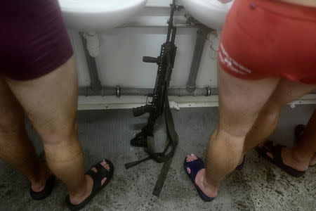 Recruits wash themselves as their weapon stands in a bathroom during their 16-day basic training for Poland's Territorial Defence Forces, at a military unit in Siedlce, Poland, December 14, 2017. REUTERS/Kacper Pempel/Files