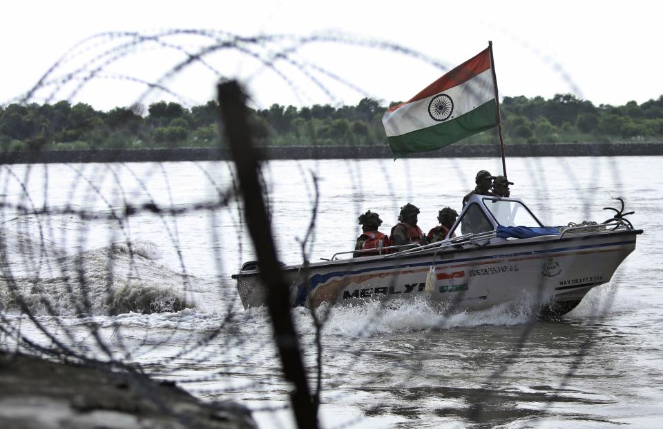 In this Tuesday, Aug. 13, 2019 file photo, Indian Border Security Force (BSF) soldiers patrol on a boat in river Chenab at Pargwal area along the India-Pakistan border in Akhnoor, about 55 kilometers (34 miles) west of Jammu, India. Pakistan's prime minister assured Kashmiri people living in the Indian-administered part of the divided region that he supports them in their struggle for self-determination. In his statement Wednesday, Imran Khan condemned New Delhi's decision Aug. 5 to downgrade Kashmir's status, as he began celebrations marking Pakistan's independence day.(AP Photo/Channi Anand)