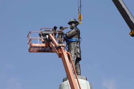 Construction workers attach a crane to a monument of Robert E. Lee, who was a general in the Confederate Army, before it is removed in New Orleans, Louisiana, U.S., May 19, 2017. REUTERS/Jonathan Bachman