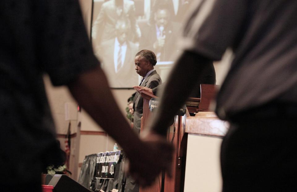 Rev. Al Sharpton, center, listens as The Rev. Jesse Jackson, not seen, leads a prayer during a community forum at the Macedonia Baptist Church in Eatonville, Fla., Monday, March 26, 2012. Students also held rallies on the campus of Florida A&M University in Tallahassee and outside the Seminole County Criminal Justice Center, where prosecutors are reviewing the case to determine if charges should be filed. (AP Photo/Julie Fletcher)