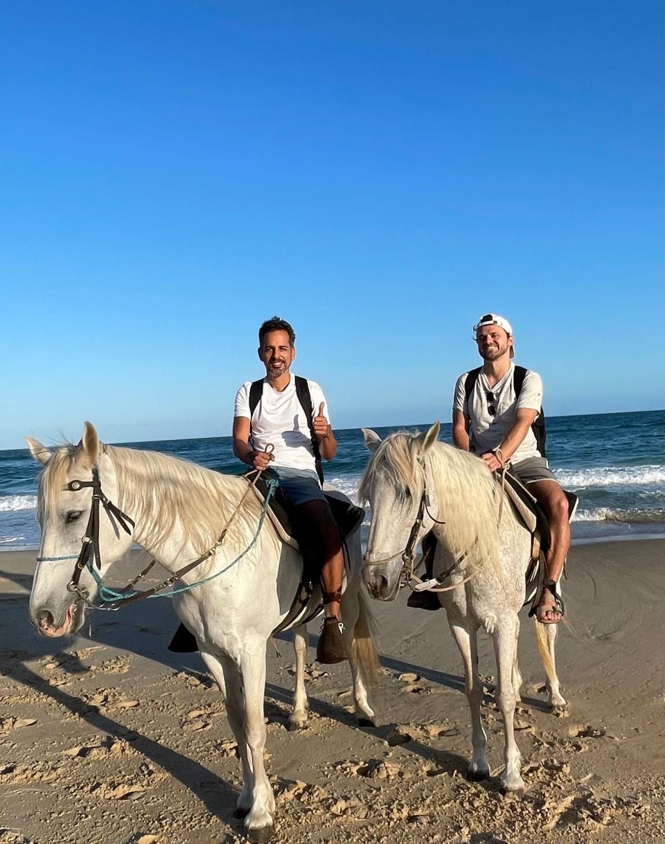 The author (right) and his partner Renzo (left) horseback riding on the beach in Florianópolis, Brazil