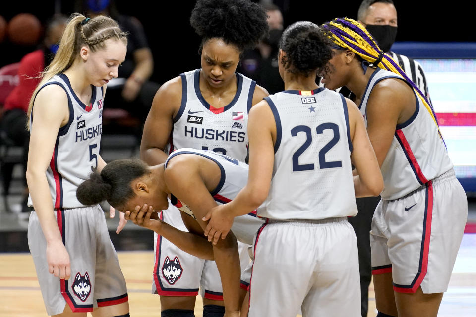 Connecticut's Aubrey Griffin is surrounded by her teammates as she holds her face after being injured during the first half of an NCAA college basketball game against the DePaul Sunday, Jan. 31, 2021, in Chicago. (AP Photo/Charles Rex Arbogast)