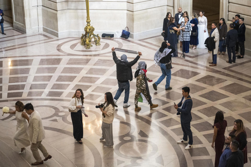 Pro-Palestinian supporters scream "Free Palestine!" as they walk through City Hall in San Francisco, Monday, Jan. 8, 2024. The city's board of supervisors is taking up a controversial resolution calling for a sustained cease-fire in Gaza, a resolution that pro-Palestinian and Jewish peace groups have successfully pushed through in other cities. (AP Photo/Nic Coury)