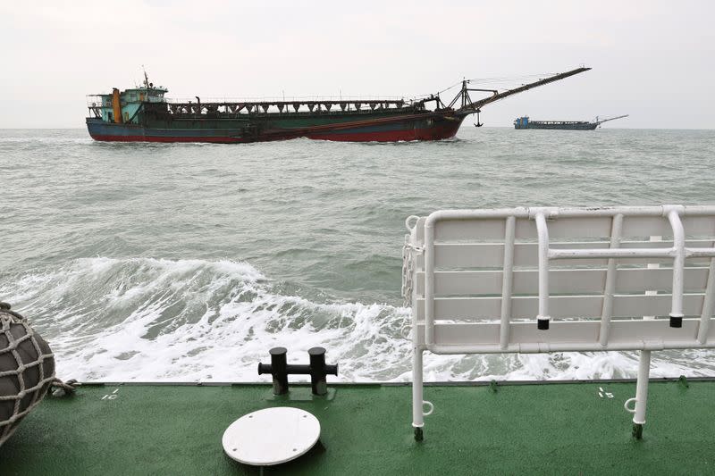 Sand-dredging ships with Chinese flags are seen from a Taiwanese coast guard ship patrolling in the waters off the Taiwan-controlled Matsu islands