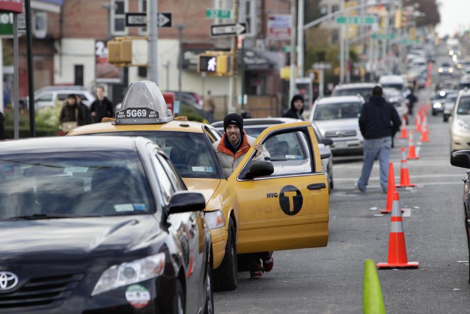 A cab driver pushes his taxi cab forward in a line for gasoline in the Brooklyn borough of New York, Friday, Nov. 2, 2012. In parts of New York and New Jersey, drivers face another day of lining up for hours at gas stations struggling to stay supplied. Superstorm Sandy damaged ports that accept fuel tankers and flooded underground equipment that sends fuel through pipelines. Without power, fuel terminals can't pump gasoline onto tanker trucks, and gas stations can't pump fuel into customers' cars. (AP Photo/Seth Wenig)