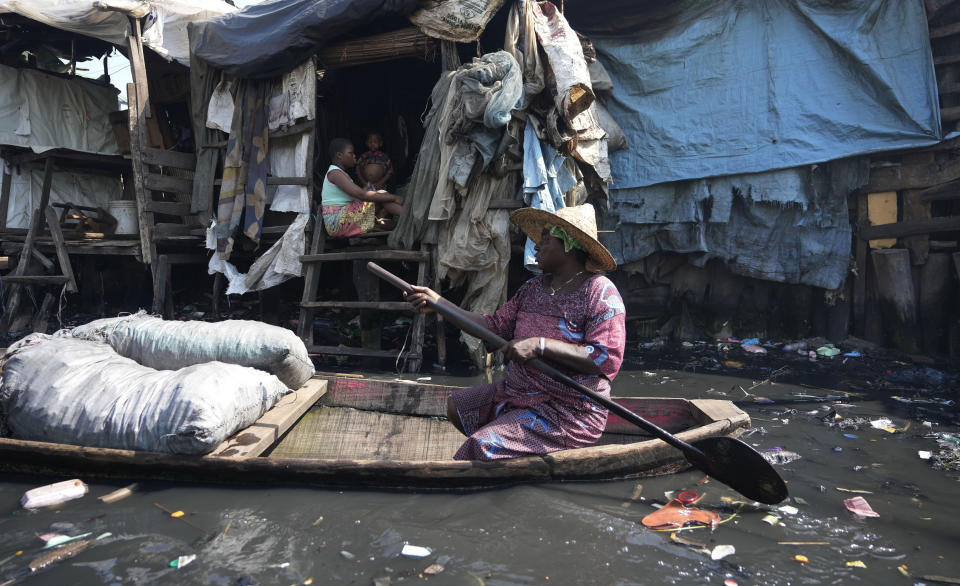 A woman paddles through filthy water surrounded by garbage in Nigeria's economic capital Lagos' floating slum of Makoko, Monday, March. 20, 2023. March 22 is World Water Day, established by the United Nations and marked annually since 1993 to raise awareness about access to clean water and sanitation. (AP Photo/Sunday Alamba)