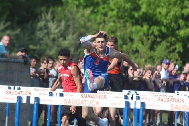 Saugatuck's Benny Diaz hurdles during a track meet in 2021