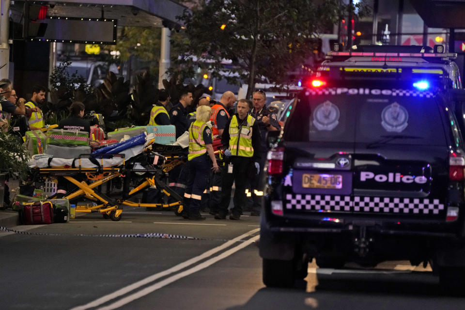 Emergency officers stand by with stretchers outside Westfield Shopping Centre where multiple people were stabbed in Sydney, Saturday, April 13, 2024. The Sydney Morning Herald reported that four people died in the stabbing. Police couldn't be immediately reached to confirm the report. The newspaper said one person was also shot, but it wasn't clear if the person had died.(AP Photo/Rick Rycroft)